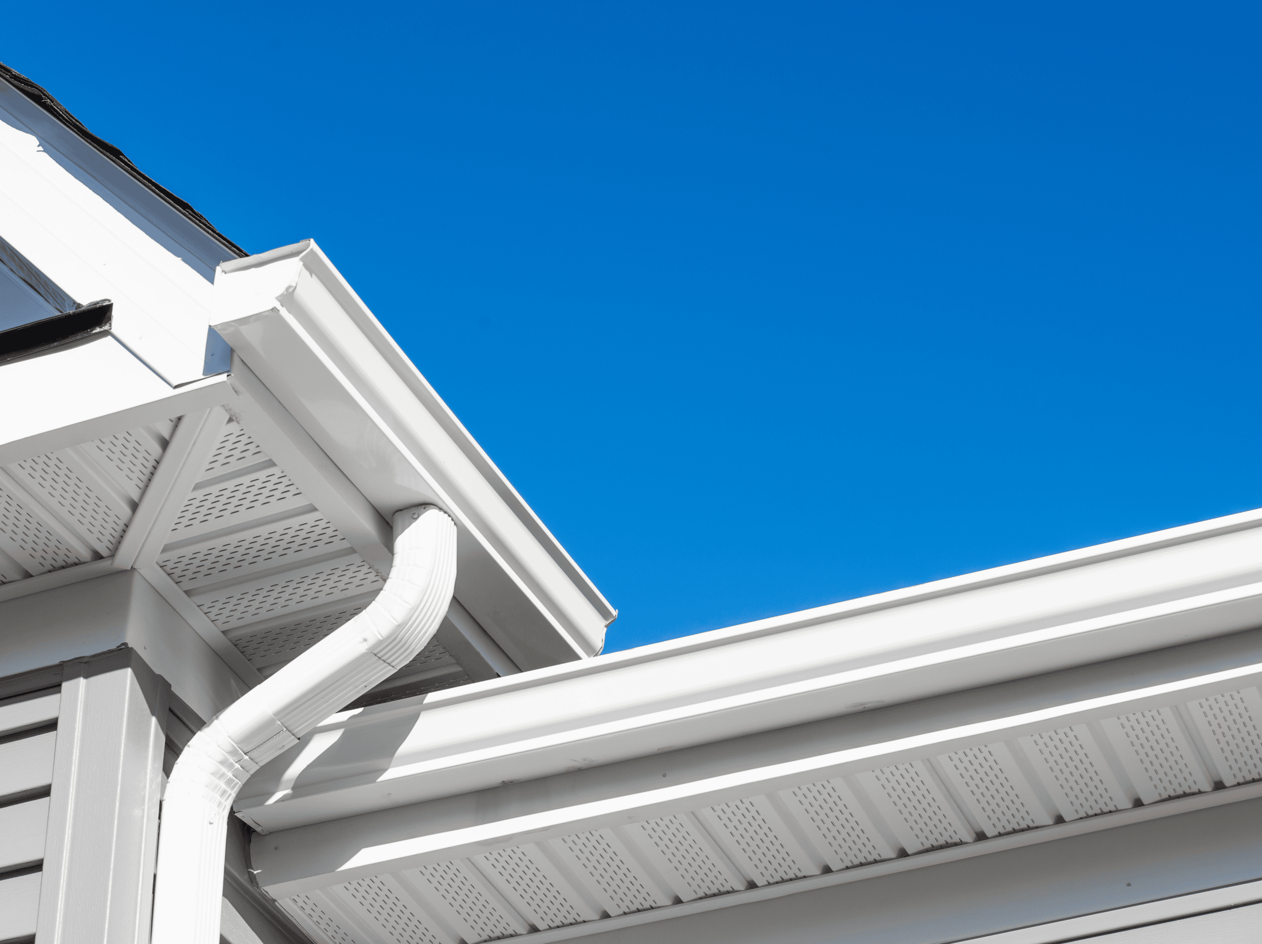 Gutter System Installation Professional gutter installation on residential home with white gutters and downspouts.