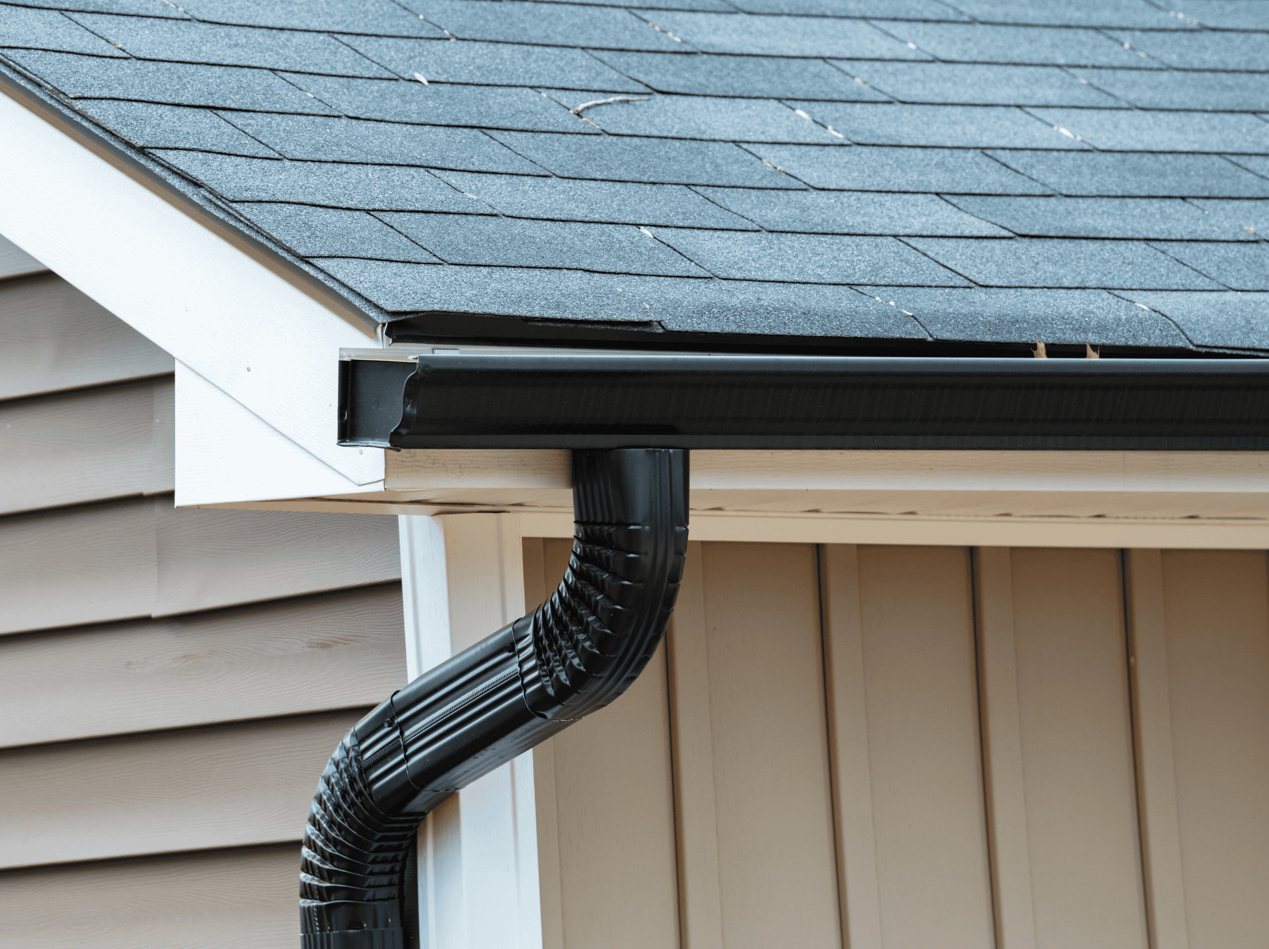 Modern black gutter system installed on residential house roof.
