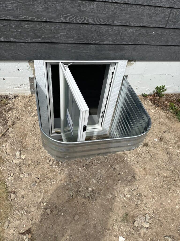 Garage Ventilation Window Small window with a vent installed in the ground outside a building for ventilation.