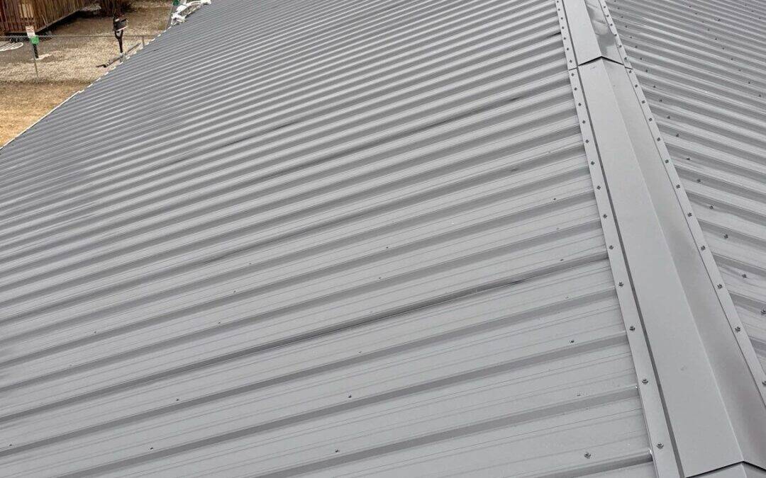 New gray metal roof installed on residential home, durable and weather-resistant.
