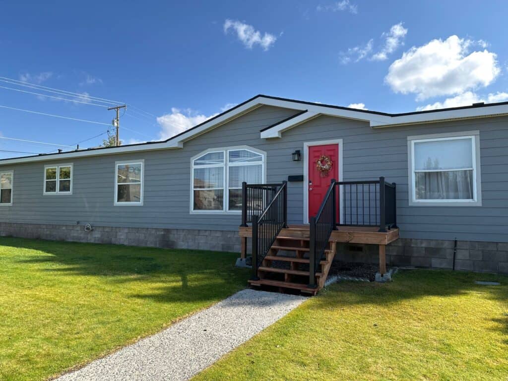 Beautiful single-story home with a vibrant red front door and well-maintained lawn.