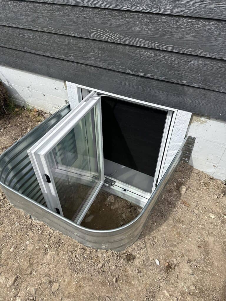 Garage Basement Access Hatch Access hatch for basement garage entry with glass door and metal frame.