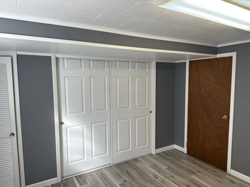 Closet with sliding doors Closet with white sliding doors in a modern basement room.