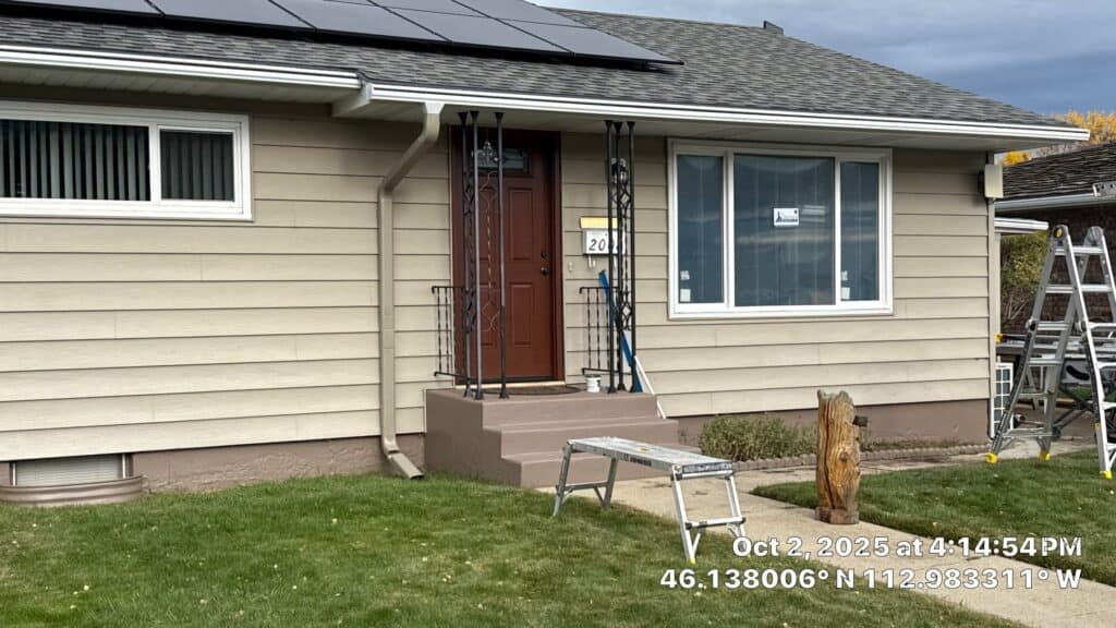Modern Window Installation Front view of a renovated house with new siding, door, and landscaping.