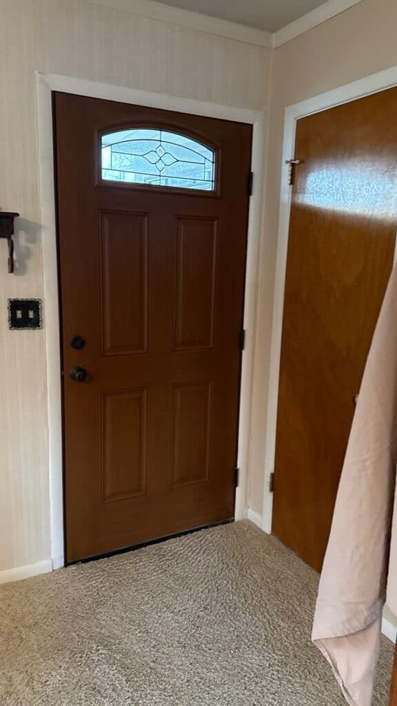 Front Door Entrance Front door with decorative glass window and wooden finish.