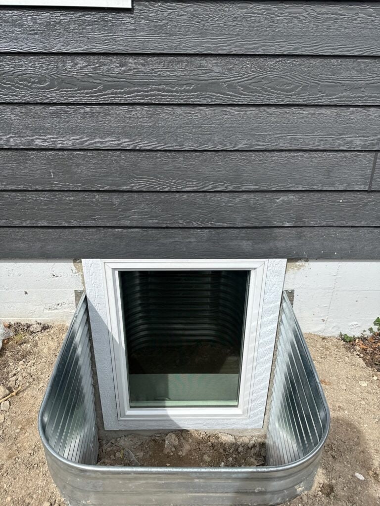 Window Well Window well with metal siding for basement window protection.