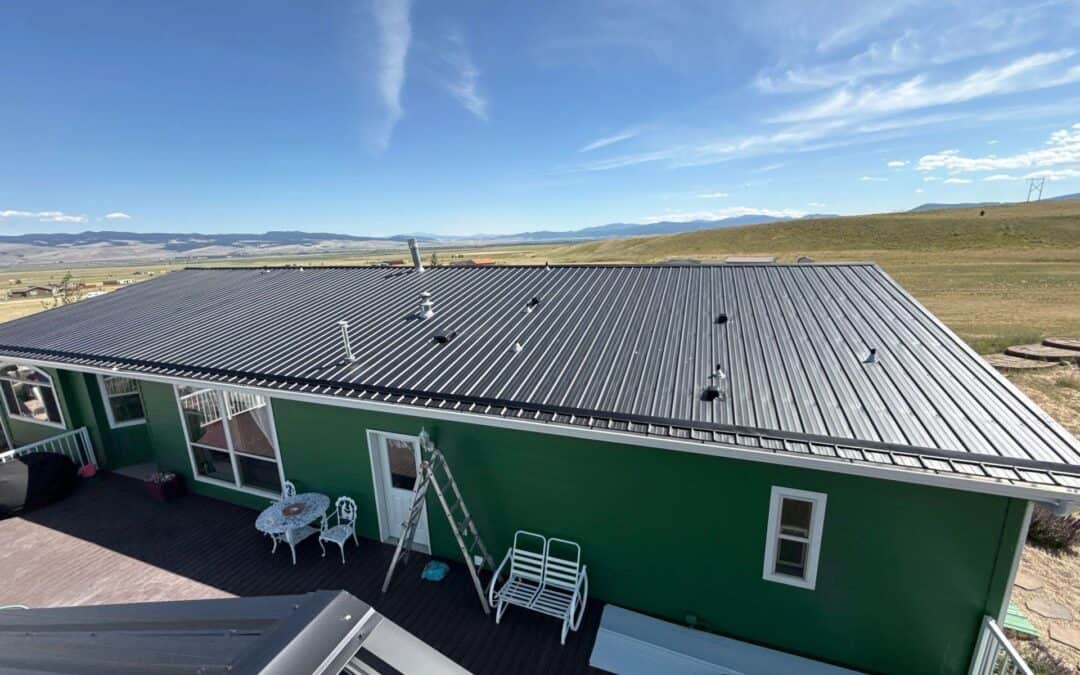 Modern green house with durable metal roofing in a scenic rural setting.