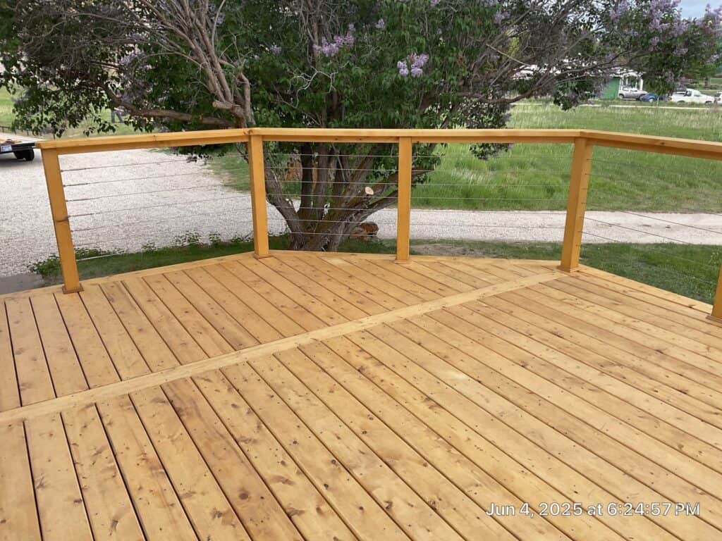 Deck Construction Deck with wooden railing and flooring in a backyard setting.