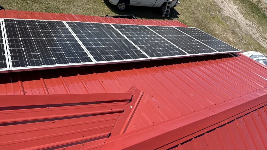 Solar panels installed on a red metal roof for renewable energy.