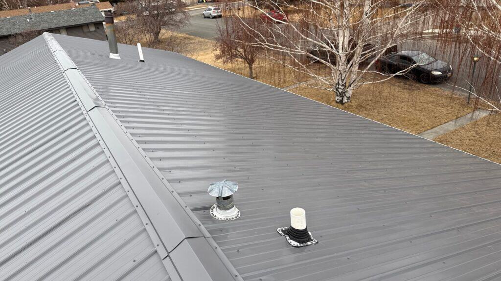 Metal roof with vents and chimney for commercial building.